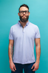 Handsome hipster guy with beard wearing blue polo t-shirt with space for your brand name or label....