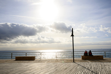 Varigotti (SV), Italy - December 30, 2017: Tourist on a bench in Varigotti beach, Italian Riviera, Savona, Liguria, Italy