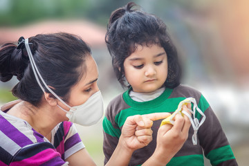 Covid-19 Coronavirus and Air pollution pm2.5 concept.Little Indian baby girl and mother wearing...