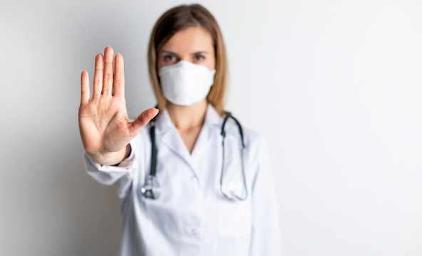 Virus mask female doctor wearing face protection in prevention for coronavirus showing gesture Stop Infection