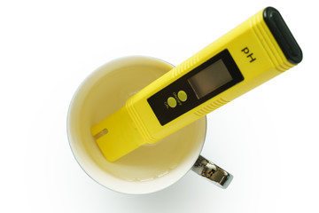 Yellow pH meter in the cup isolated on white background