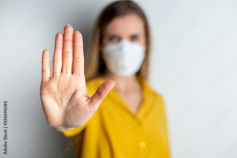 Wall mural virus mask woman wearing face protection in prevention for coronavirus showing gesture stop infectio