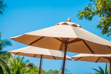 Fototapeta na wymiar Umbrella and chair around sea beach ocean with coconut palm tree on blue sky background