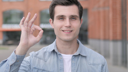Okay by Satisfied Young Man Standing Outdoor