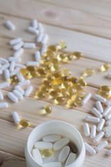 white and yellow medicine on light wood