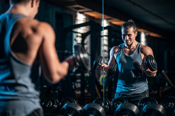 young athlete has physical workout with dumbbell in modern gym