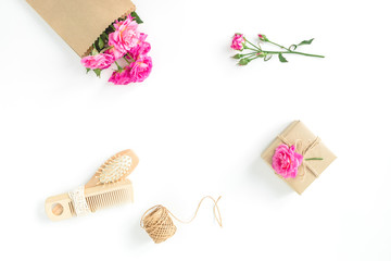 Beauty composition of roses with hairbrush, tassel and gift on white. Flat lay, top view