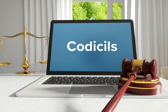 Codicils – Law, Judgment, Web. Laptop in the office with term on the screen. Hammer, Libra, Lawyer.