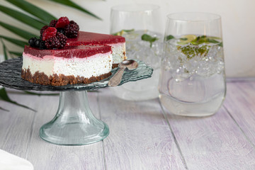 Cheesecake on two white plates, two servings. On a white background decorated with fresh berries. Birthday, holidays, sweets. I drink nearby.