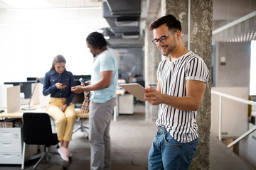 Fototapeta premium Young man using technology, digital tablet in corporate business office