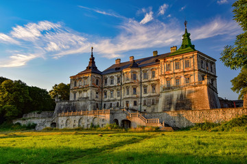 Fototapeta premium Stunning morning view of medieval Pidhirtsi Castle illuminated by rising sun, Pidhirtsi village, Lviv region, Ukraine