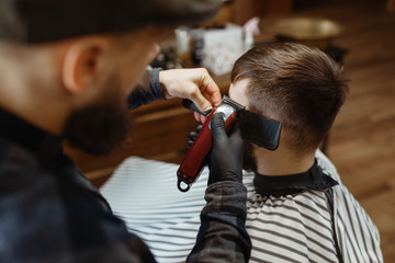 Barber in hat cuts the client 's hair, barbershop