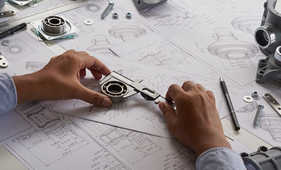 Engineer technician designing drawings mechanical parts engineering Engine.manufacturing factory...