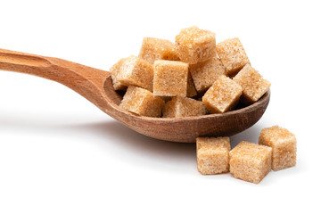 brown refined sugar in a wooden spoon on a white background
