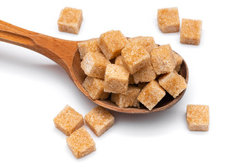 brown refined sugar in a wooden spoon on a white background