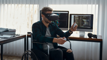 Powerful tool. Portrait of young male web developer in a wheelchair wearing virtual reality headset...
