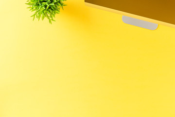 Office desktop with computer on yellow background with copyspace. Flat lay