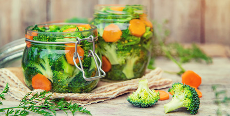 Preservation of broccoli with carrots in jars. Selective focus.