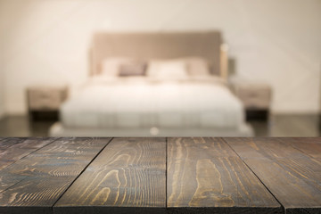 Empty wooden board and blurred modern bedroom with house interior as background. Abstract pattern.