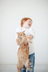 Funny red-haired boy with a red cat