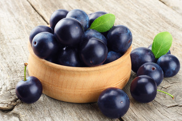 blackthorn berries with green leaf on old wooden table