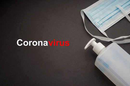 CORONAVIRUS text with antibacterial soap sanitizer and protective face mask on black background. Covid-19 or Coronavirus Concept