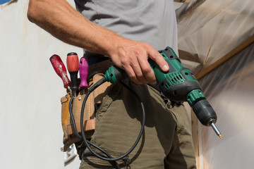 Close up drill in construction worker hands.