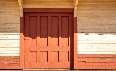 Old red door with heavy shadow.
