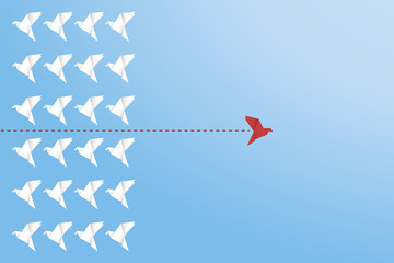 Think differently concept. Be different. Red bird changing direction. New idea, change, trend, courage, creative solution, innovation and unique way concept	
