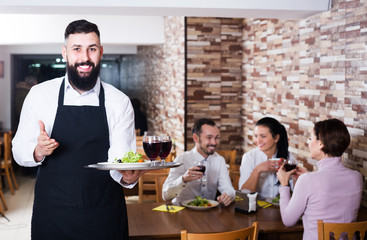 Fototapeta na wymiar Waiter welcoming guests in restaurant