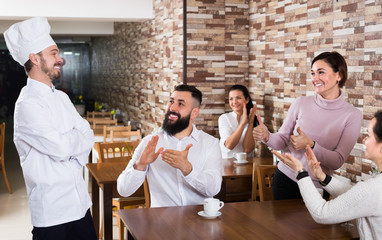 Smiling chef listens to praise of the food