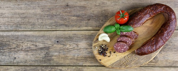 Smoked salami homemade with spices on a rustic wooden background - top view with free space for your text