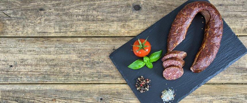  Smoked salami homemade with spices on a rustic wooden background - top view with free space for your text