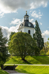 White church tower surrounded by lush green trees