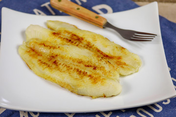 filet de tilapia en train de cuire dans une assiette