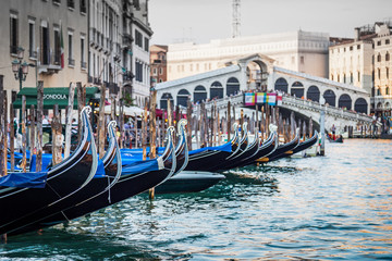 Gondolas moored to the quays of Venice on the Grand Canal with the Rialto bridge in the background