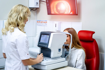 Young woman checking vision. Medical examination at the ophthalmological office. Eye health concept. Optometrist performing visual field test - obrazy, fototapety, plakaty