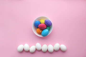 Easter eggs on pink background. Colorful eggs on the plate. Easter preparation.