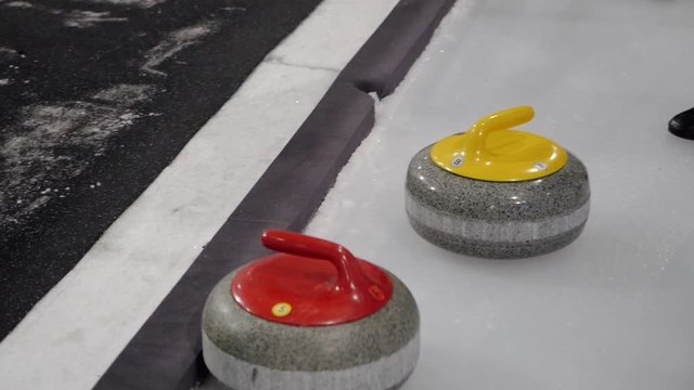 The curling stone hits another curling stone.