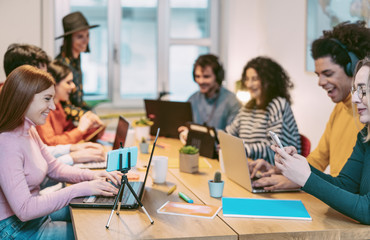 Happy young people working together inside office - Multiracial friends having fun in coworking space - Youth co-workers millennial generation and technology workspace concept