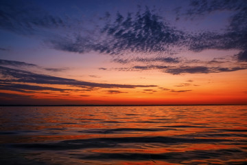 Fototapeta na wymiar Beautiful colorful sunset on the sea coast. Nice scene with sunrise over water