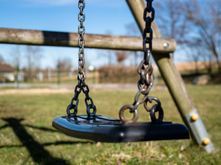Verwaiste Schaukel in einem Park, Ausgangsbeschränkung in Österreich, Einsamkeit