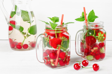 Fresh cool drink of ripe juicy cherry, strawberry, currant and gooseberry berries