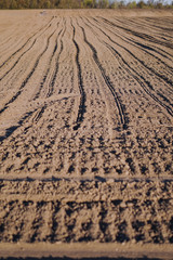 Plowed endless farm field. The fertile land of the agricultural sector. Sowing on black soil in the garden. Industrial stock theme