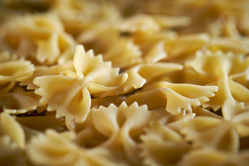 Dried farfalle short pasta background 