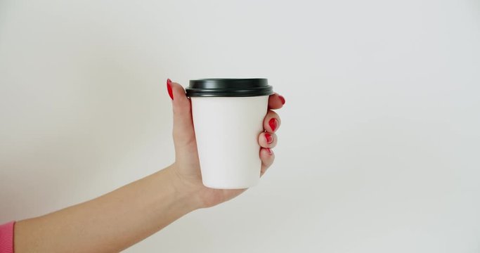 Mockup of female hand holding coffee paper cup