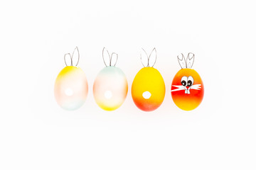 Colorful painted easter eggs with funny bunny ears and cartoon faces on white background