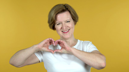 The Handmade Heart by Old Woman Isolated on Yellow Background