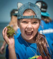 Summer camp. Szczęśliw i uśmiechnięta dziewczynka spędza wakacje nad morzem razem z innymi dziećmi na kolonii