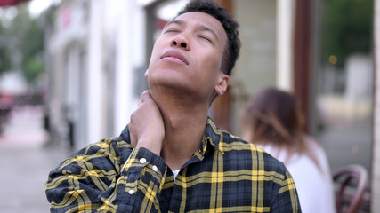 Obraz premium The Tired Young African Man with Neck Pain